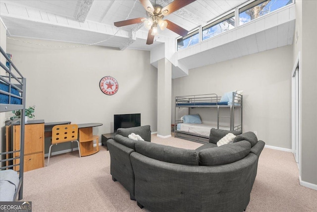 living room featuring beamed ceiling, carpet floors, and ceiling fan