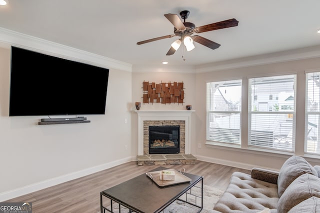 living room with ornamental molding, a wealth of natural light, and light hardwood / wood-style flooring