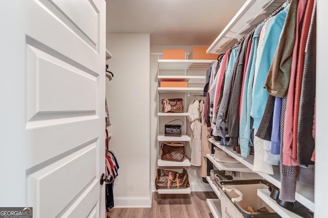 spacious closet with light hardwood / wood-style flooring