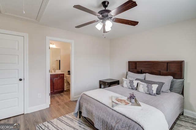 bedroom with ceiling fan, sink, light hardwood / wood-style floors, and ensuite bathroom