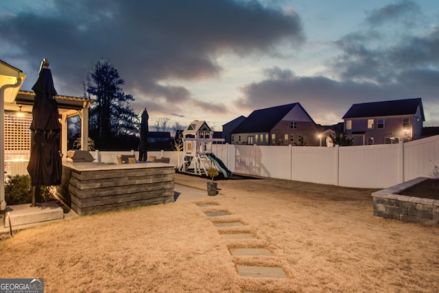 yard at dusk with a playground and outdoor lounge area