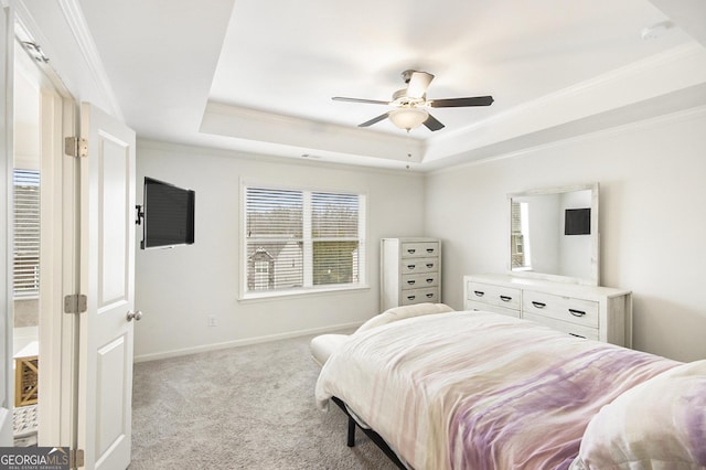 carpeted bedroom featuring a raised ceiling, crown molding, and ceiling fan