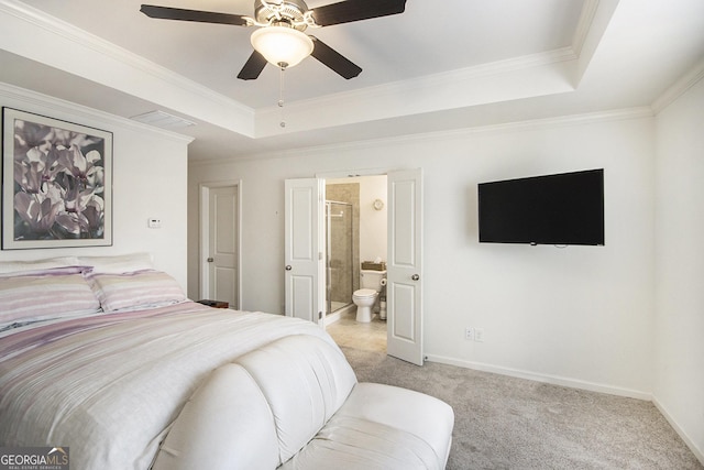 bedroom featuring a tray ceiling, ornamental molding, light colored carpet, and ensuite bathroom