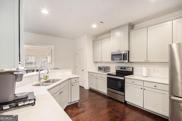 kitchen with stainless steel appliances, tasteful backsplash, sink, and white cabinets