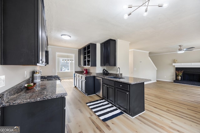 kitchen with crown molding, dishwasher, and dark stone countertops