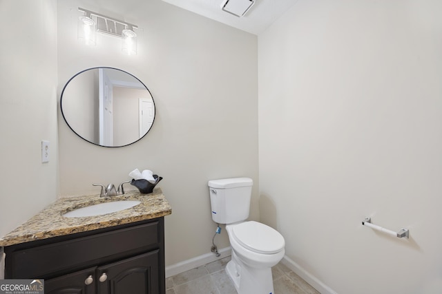 bathroom featuring vanity, tile patterned flooring, and toilet