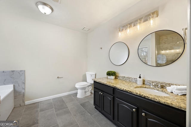 bathroom featuring vanity, a tub to relax in, and toilet