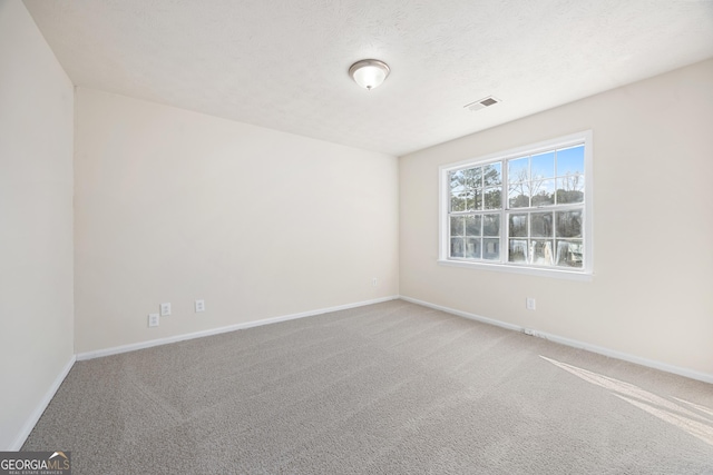 spare room featuring carpet flooring and a textured ceiling