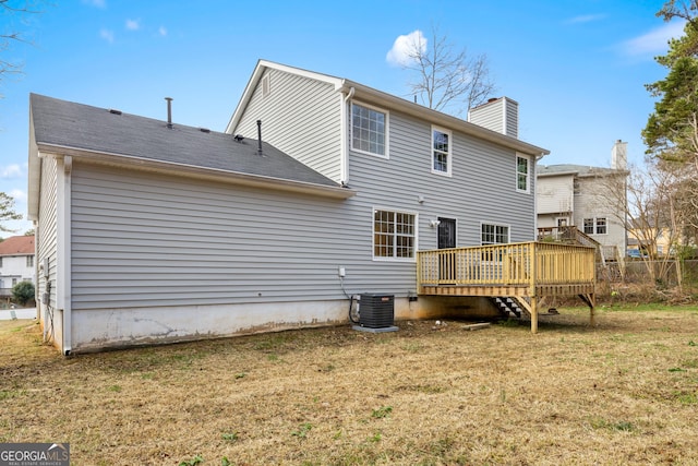 rear view of property featuring a wooden deck, central air condition unit, and a lawn