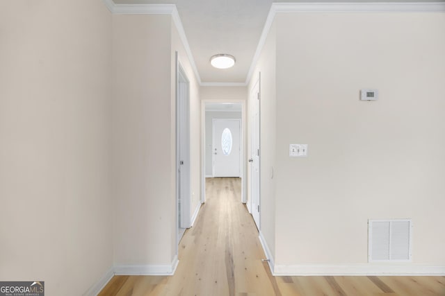 hallway with ornamental molding and light hardwood / wood-style floors