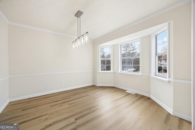 unfurnished dining area with ornamental molding and light hardwood / wood-style floors