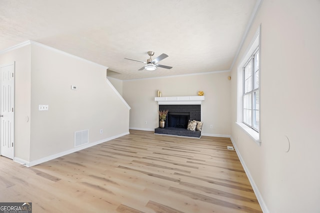 unfurnished living room with ornamental molding, a fireplace, light hardwood / wood-style floors, and ceiling fan