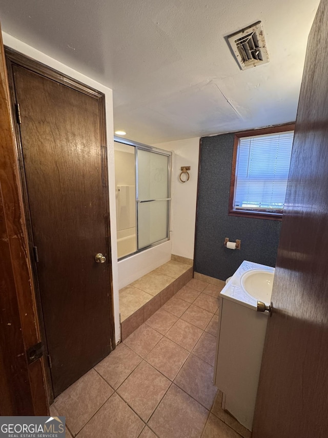 bathroom with tile patterned flooring, vanity, and shower / bath combination with glass door