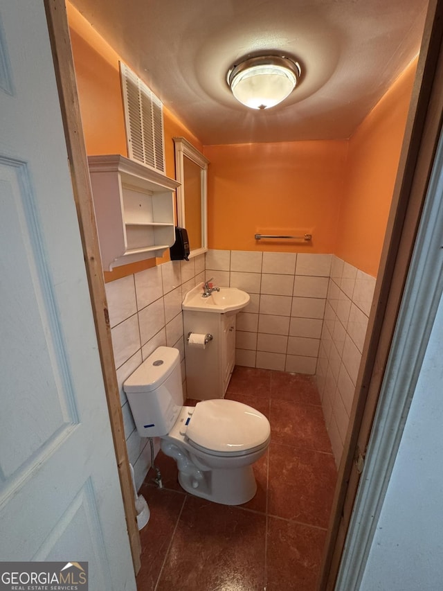 bathroom with tile walls, vanity, tile patterned floors, and toilet