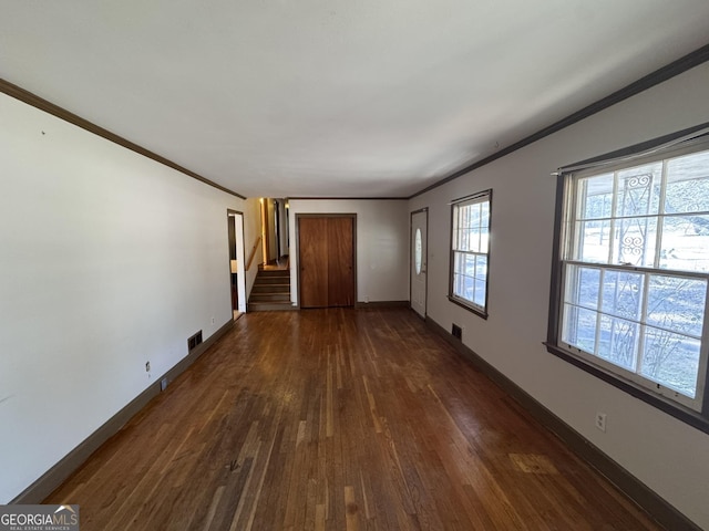 empty room with ornamental molding and dark hardwood / wood-style floors