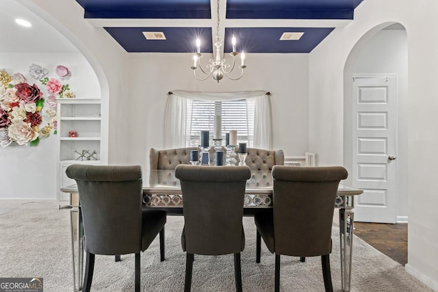 dining room with beamed ceiling, coffered ceiling, and a notable chandelier