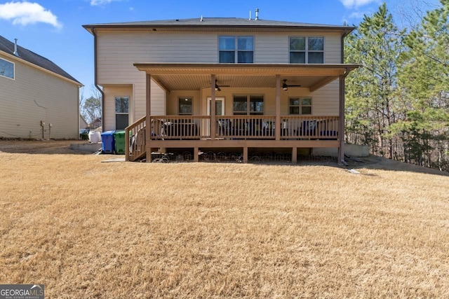 rear view of house with ceiling fan, a yard, and a deck