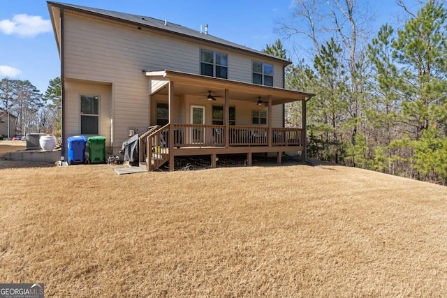 rear view of house with a wooden deck, ceiling fan, and a lawn