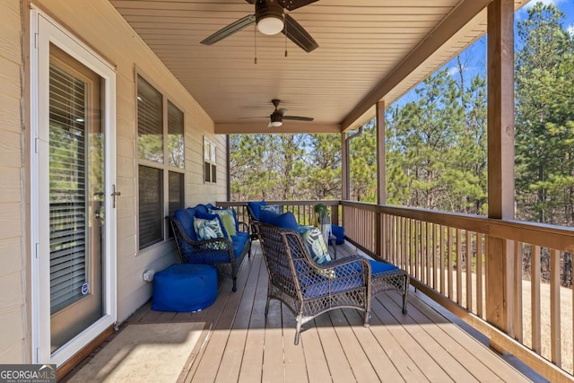 wooden deck featuring an outdoor living space and ceiling fan