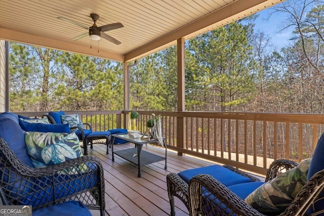 wooden terrace featuring outdoor lounge area and ceiling fan