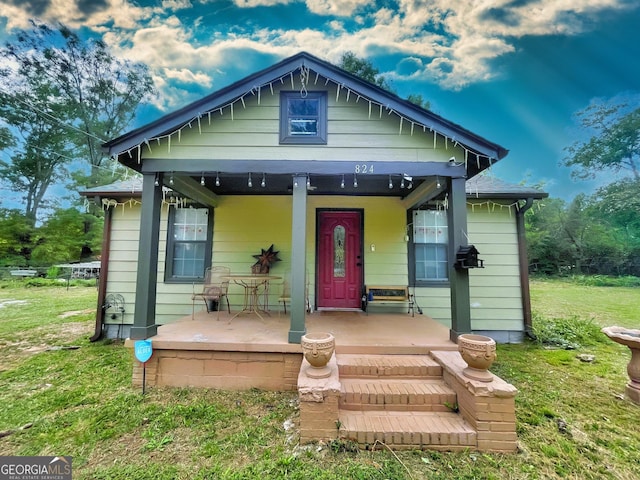 bungalow-style home with a front lawn and a porch