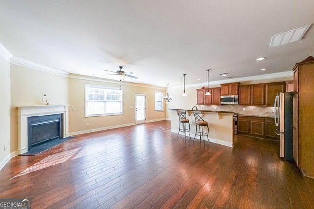 unfurnished living room with dark wood-type flooring, ceiling fan, and crown molding