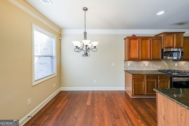 kitchen featuring pendant lighting, stainless steel appliances, tasteful backsplash, and dark stone countertops