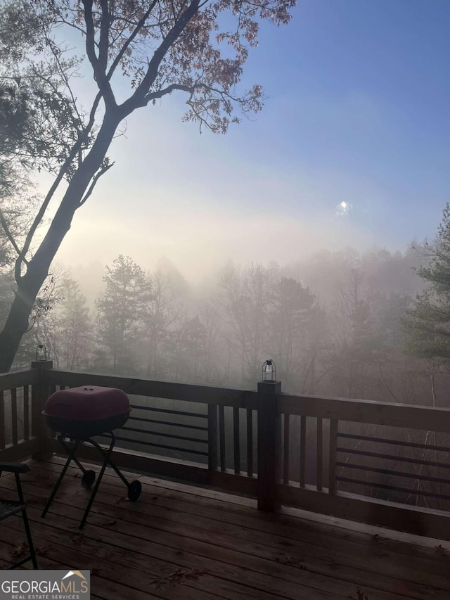 deck at dusk featuring grilling area