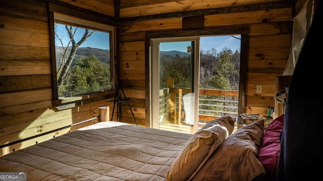 bedroom featuring a mountain view and wood walls