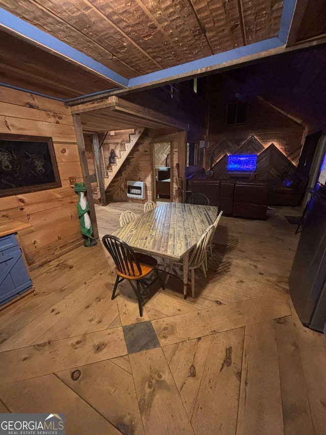 dining room featuring wooden walls, hardwood / wood-style floors, and heating unit