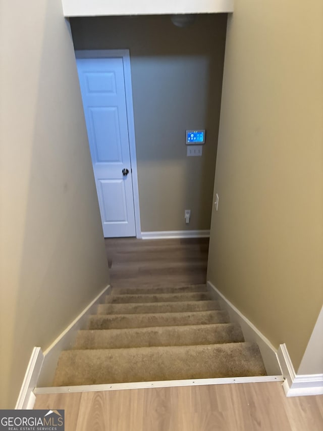 staircase with hardwood / wood-style flooring