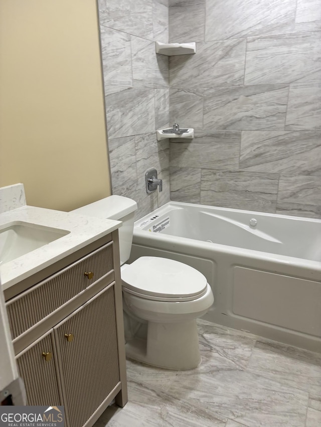 full bathroom featuring vanity, tiled shower / bath, and toilet