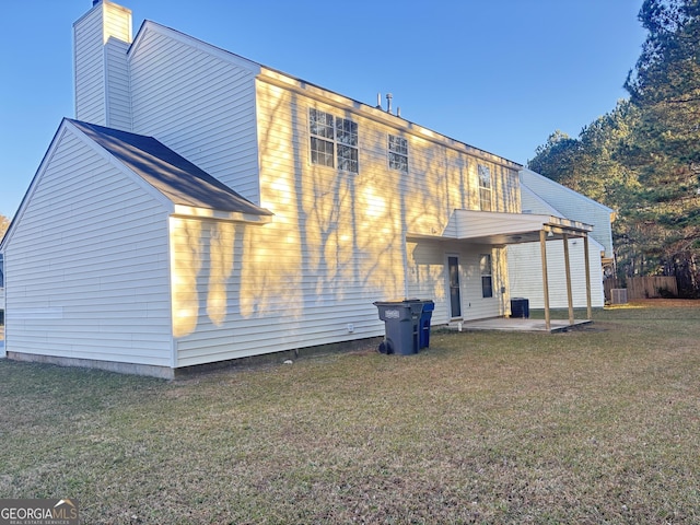 back of house featuring a yard and a patio area