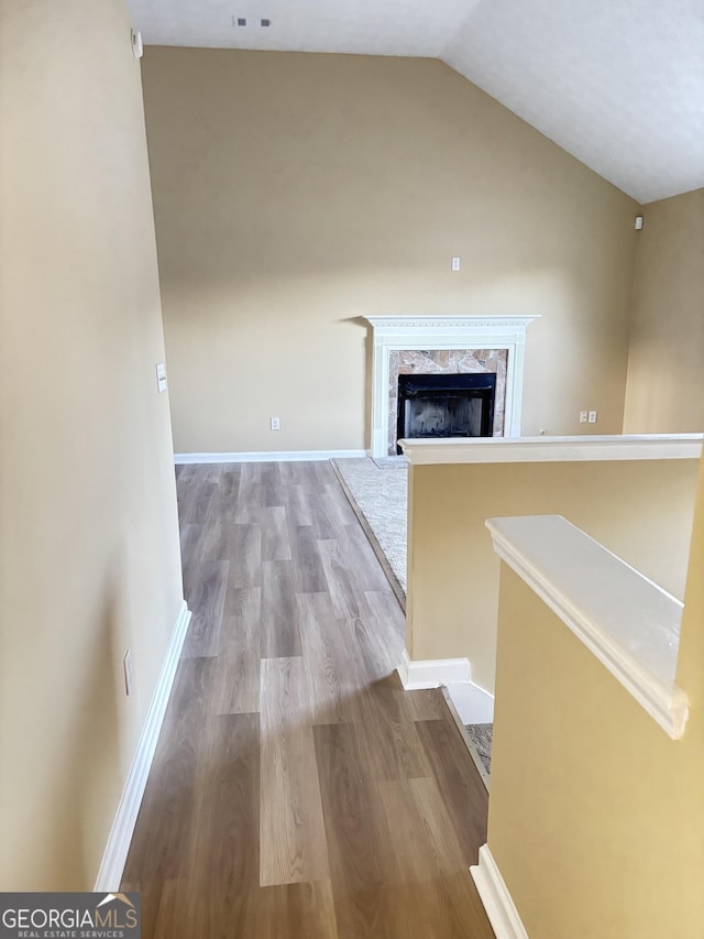 hall featuring light hardwood / wood-style floors and vaulted ceiling