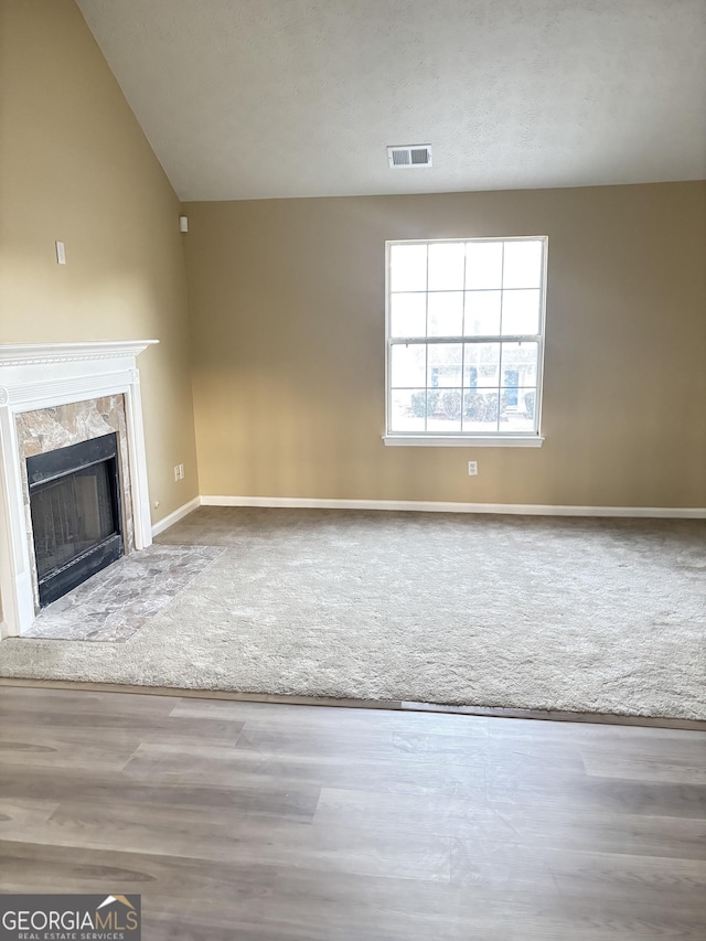 unfurnished living room with a fireplace and carpet