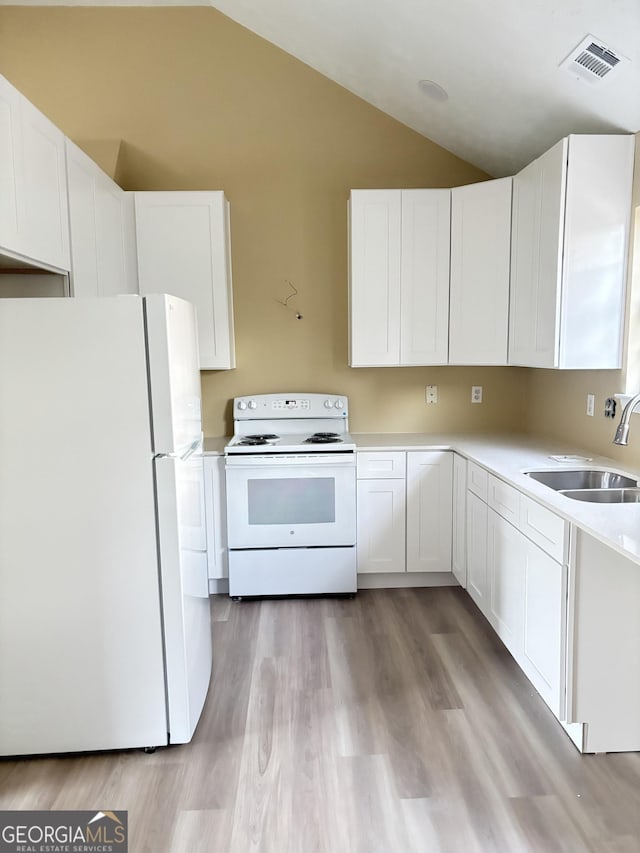 kitchen with white cabinetry, sink, white appliances, and lofted ceiling