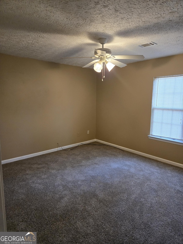 spare room with carpet, a textured ceiling, and ceiling fan