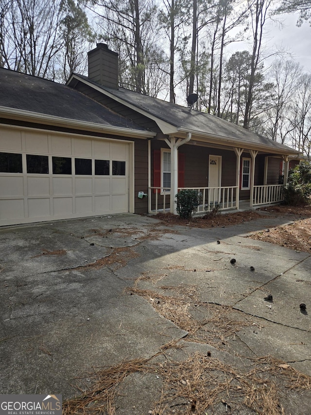 ranch-style home with a porch and a garage