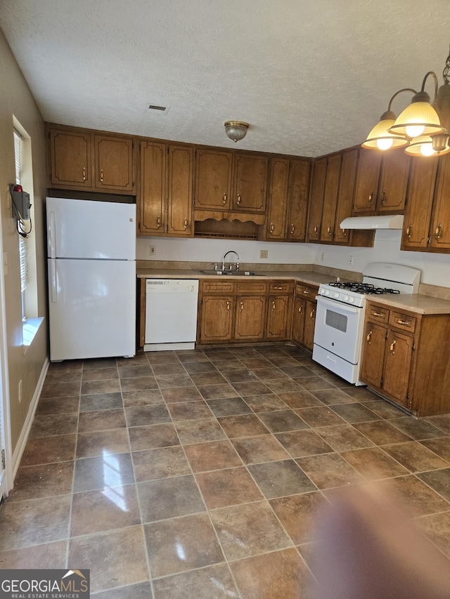 kitchen with sink, white appliances, and a textured ceiling