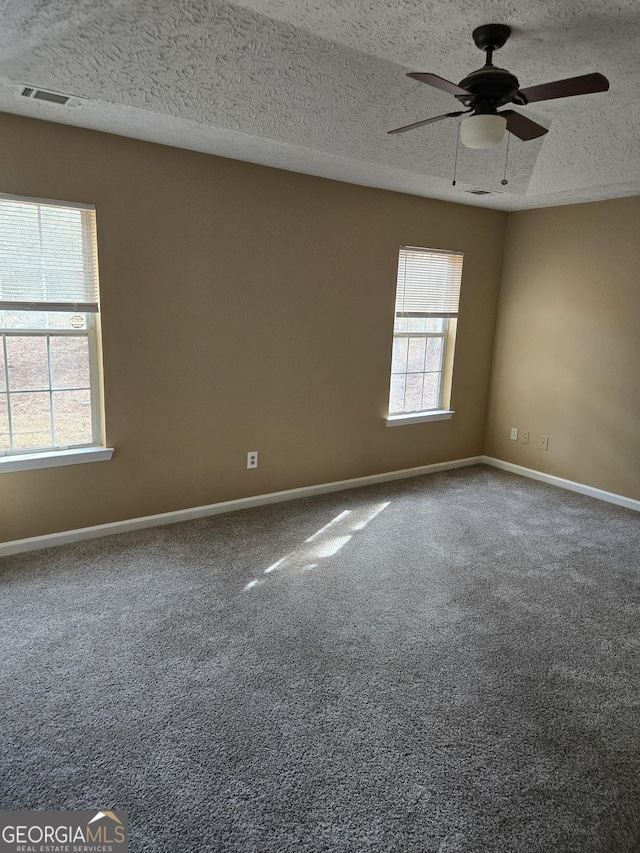 carpeted spare room featuring a textured ceiling and ceiling fan