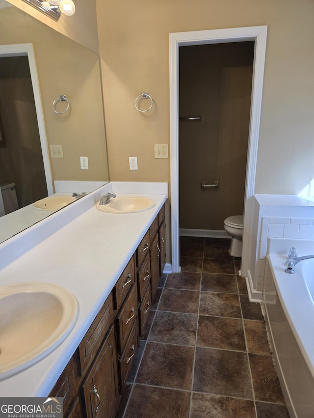 bathroom with vanity, toilet, and a tub