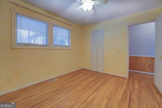 unfurnished bedroom featuring multiple windows, light hardwood / wood-style floors, a closet, and ceiling fan