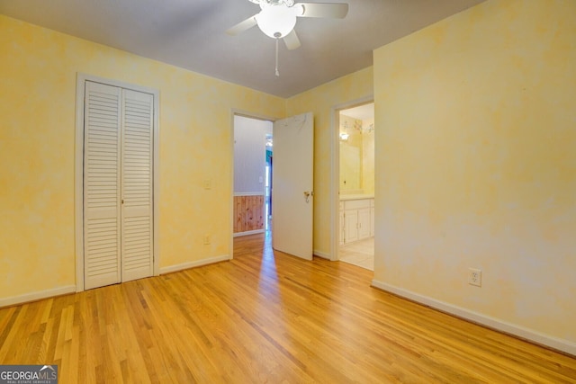 unfurnished bedroom featuring ceiling fan, a closet, ensuite bath, and light hardwood / wood-style flooring