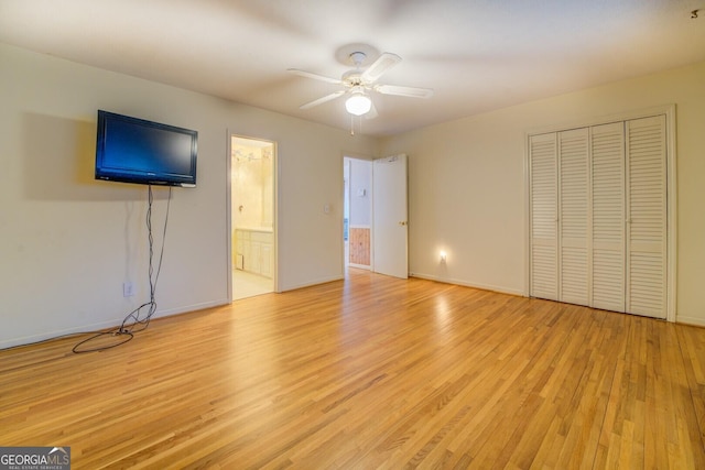 unfurnished bedroom featuring ceiling fan, ensuite bathroom, a closet, and light wood-type flooring