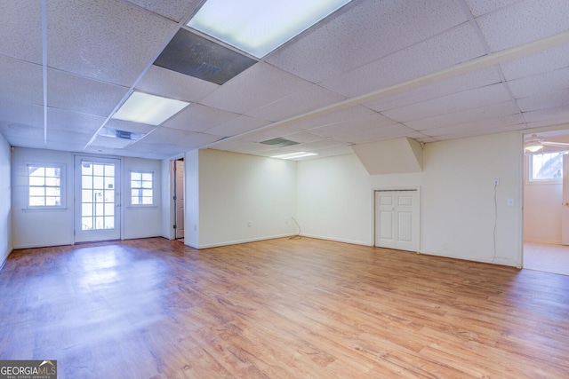 basement with a drop ceiling and light wood-type flooring