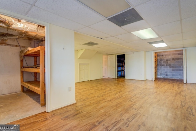 basement with a paneled ceiling and hardwood / wood-style floors