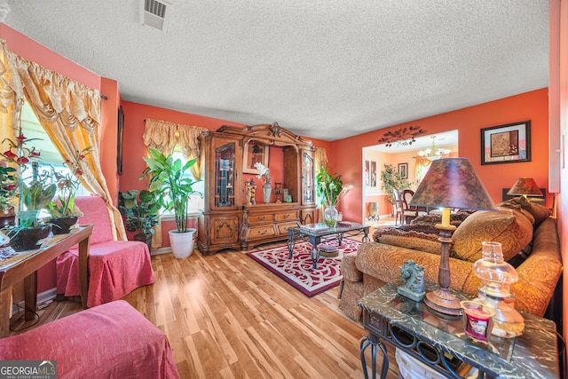 living room featuring a textured ceiling and light wood-type flooring