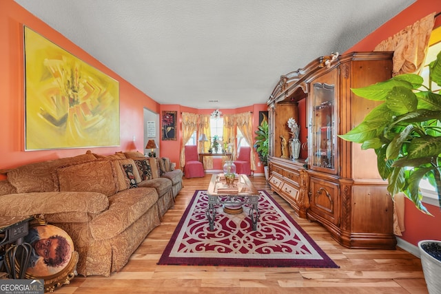 living room with a textured ceiling and light wood-type flooring