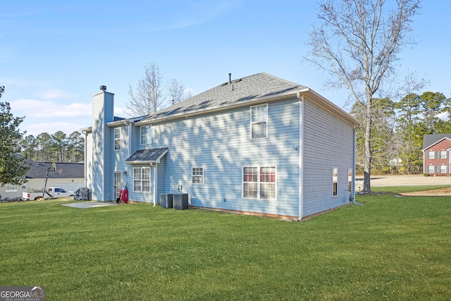 back of house with a patio area and a lawn