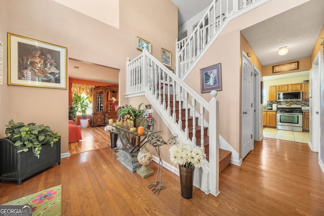 stairway featuring hardwood / wood-style floors and a high ceiling